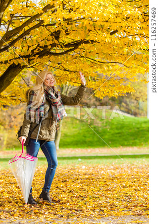Woman walking in park with umbrella 116257469