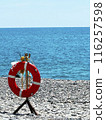 Lifebuoy on the seashore. Beach safety equipment. Positioned by water s edge for emergencies and rescue purposes 116257598