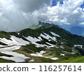 View of the Mountains landscape. Green mountain slopes with snow. Grassy field and rolling hills 116257614