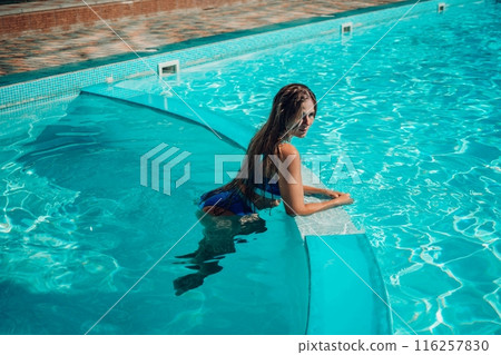 woman swimming pool. happy woman with long hair and stylish sunglasses sunbathing in pool woman swimming pool. happy woman with long hair and stylish sunglasses sunbathing in pool 116257830