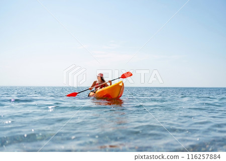 Kayak sea woman. Happy attractive woman with long hair in red swimsuit, swimming on kayak. Summer holiday vacation and travel concept. Kayak sea woman. Happy attractive woman with long hair in red swimsuit, swimming on kayak. Summer holiday vacation and travel concept. 116257884