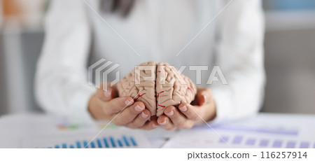Woman holding on hands two pieces of human brain, female show fullness on person mind 116257914