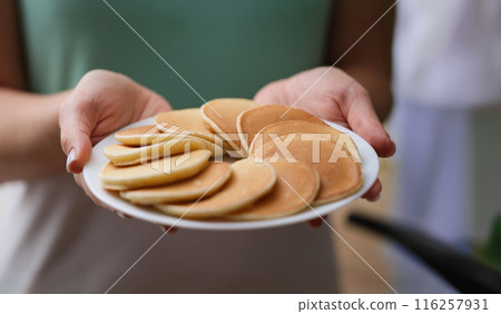 Woman holding plate with tasty fresh homemade pancakes 116257931