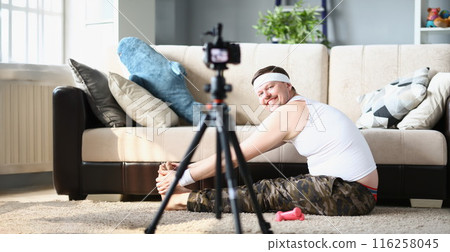 Happy man in sportswear exercise with joy, stretching on floor carpet 116258045