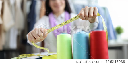 Seamstress stylist keeps centimeter at workplace closeup 116258088