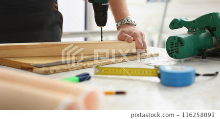 Workers instruments for repairing, man drill hole in wooden plank Workers instruments for repairing, man drill hole in wooden plank 116258091