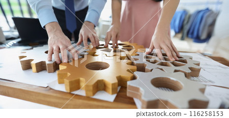 Businesspeople put wooden gears on workplace together, work in team 116258153