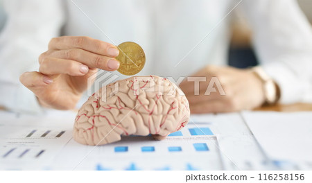 Businesswoman holding bitcoin coin in front of human brain 116258156