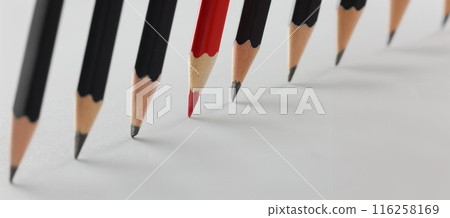 Tips of group of pencils put on paper in strict order, red among black pens 116258169