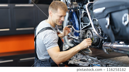 Qualified handyman with tool fix damaged motorbike in garage 116258182