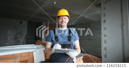 Worker hold clipboard and write down consumable materials for renovation 116258215