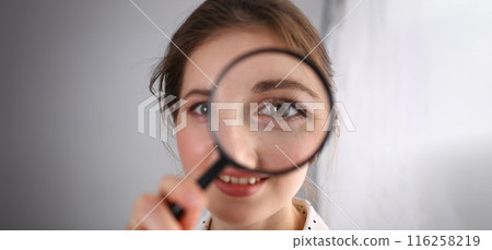Young woman look through magnifying loupe, interested in everything Young woman look through magnifying loupe, interested in everything 116258219