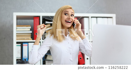 Happy worker got good news on phone, chatting during work time, excited to hear 116258222