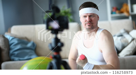Middle aged man training with dumbbells, record on videocamera 116258973