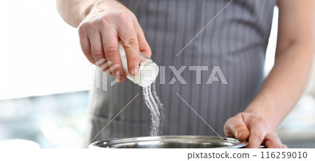 Professional cook hold saltcellar and add salt to soup, chef follow recipe, nutritious meal 116259010