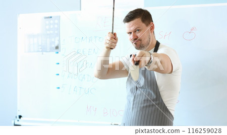 Standing man hold sharp kitchenware for cooking, knife sharpening on kitchen 116259028