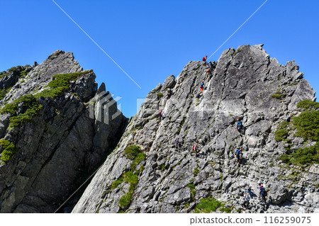 危險的登山,用鐵鍊攀爬岩石區,景色壯觀 危險的登山,用鐵鍊攀爬岩石區,景色壯觀 116259075