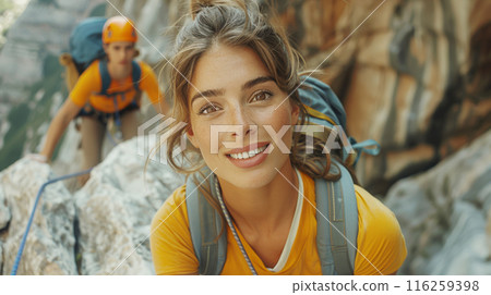 Caucasian young woman is climbing on steep rock cliff on mountain. Adventure and destination travel 116259398