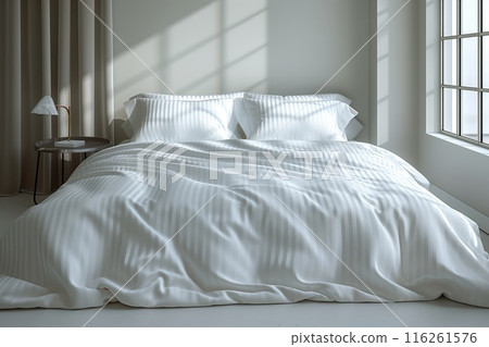 comfortable bed, white sheets and pillows in a room, featuring flooring and a rectangular bed frame 116261576