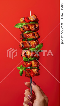 Chicken kebab on skewers with tomatoes and parsley on a red background 116261588