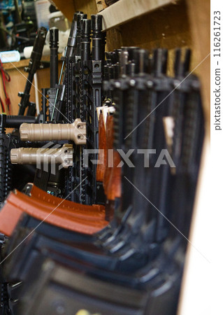 airsoft weapons lie in rows in the warehouse ready for the game airsoft weapons lie in rows in the warehouse ready for the game 116261723