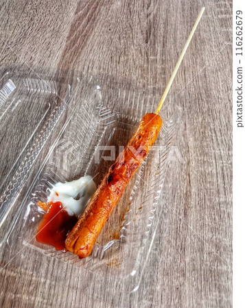 Red fish hook on a white wooden background Red fish hook on a white wooden background 116262679