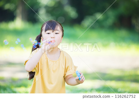Elementary school girl playing with soap bubble Elementary school girl playing with soap bubble 116262752