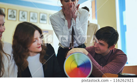 Students in physics class spin Newton's colorful wheel. 116262921