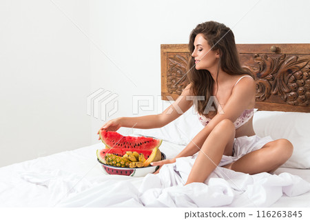Beautiful woman and bowl with sweet fruits in the bed 116263845
