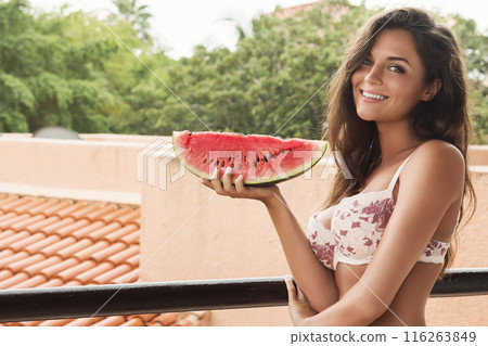 Beautiful woman and slice of watermelon on the balcony 116263849