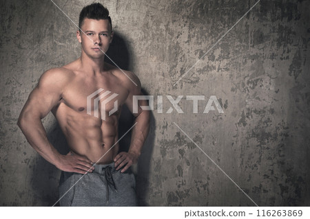 Handsome and muscular guy against concrete wall Handsome and muscular guy against concrete wall 116263869