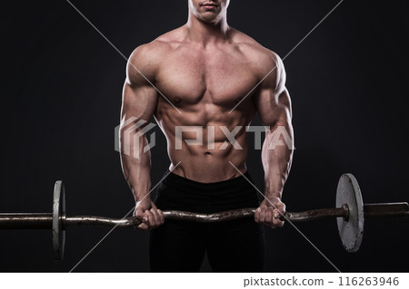 Young man bodybuilder with barbell in studio Young man bodybuilder with barbell in studio 116263946