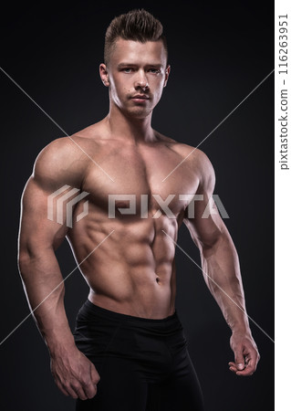 Young bodybuilder is showing his muscles in studio 116263951
