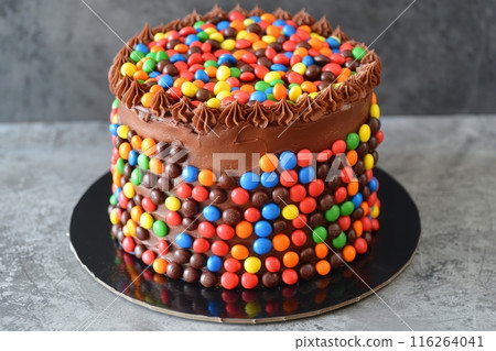 A chocolate cake frosted with chocolate frosting and decorated with colorful candies. 116264041