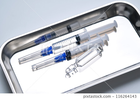Syringes with needles and an ampoule in a stainless steel medical tray. Syringes with needles and an ampoule in a stainless steel medical tray. 116264143