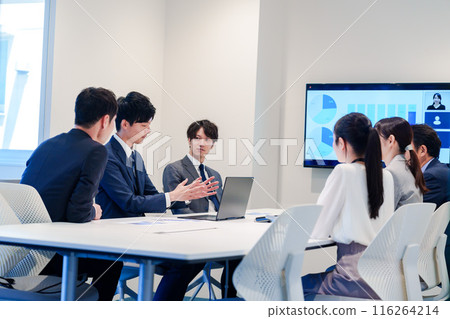 A young man wearing a suit speaking at a meeting A young man wearing a suit speaking at a meeting 116264214