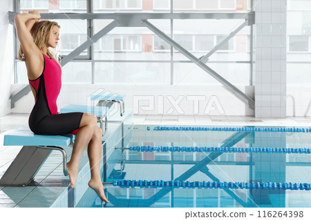 Professional female swimmer sitting beside the pool 116264398
