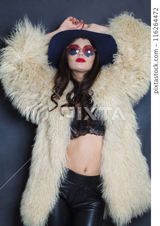 Standing young brunette lady with makeup and long curly hair posing Standing young brunette lady with makeup and long curly hair posing 116264472