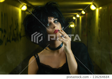 Freaky woman with black hair smoking a cigarette Freaky woman with black hair smoking a cigarette 116264684
