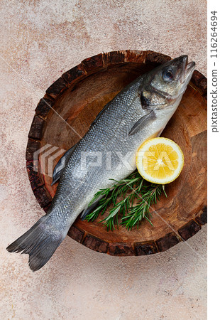 fresh, raw sea bass fish, in a wooden plate, top view, no people. fresh, raw sea bass fish, in a wooden plate, top view, no people. 116264694
