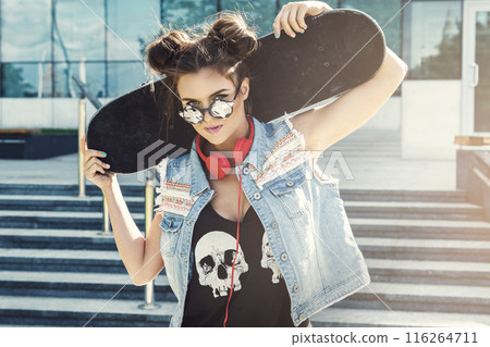 Stylish girl with a skateboard on street 116264711