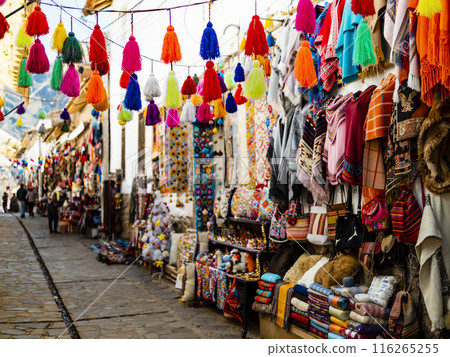 Colorful alley with handmade souvenirs in traditional Pisac market, Cusco region, Peru Colorful alley with handmade souvenirs in traditional Pisac market, Cusco region, Peru 116265255