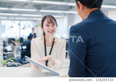 A female staff member assisting visitors at the counter 116265310