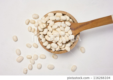 Raw white beans in a plate on the table, top view. 116266104