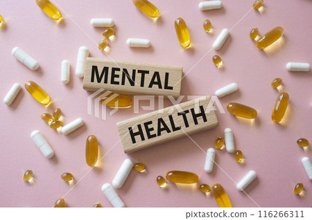 Mental Health symbol. Concept word Mental Health on wooden blocks. Beautiful pink background with pills. Medicine and Mental Health concept. Copy space 116266311