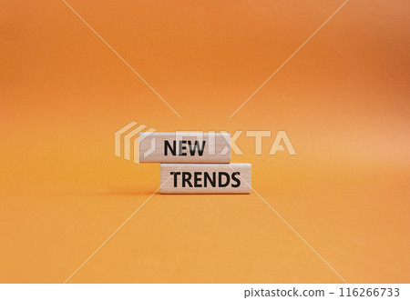New Trends symbol. Wooden blocks with words New Trends. Beautiful orange background. Business and New Trends concept. Copy space. 116266733
