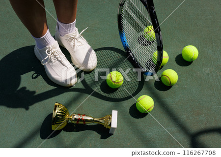 young female tennis player celebrating victory on the court, close-up of cup and tennis racket, victory in tennis tournament 116267708
