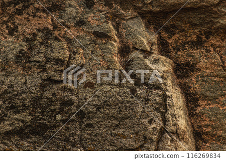 Dark red orange brown stone with cracks Closeup of uneven mountain surface 116269834