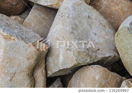 Closeup of smooth river rocks displaying a variety of warm tones and textures 116269967