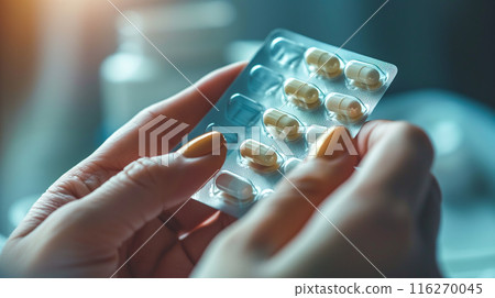 Woman's hand holding a pill. Image of a woman taking contraceptive pills 116270045